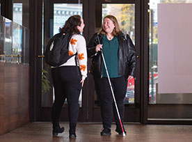 Two women talking in the building entry. Links to Beneficiary Designations